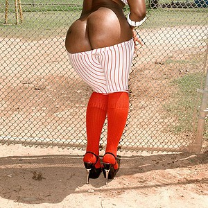 Ebony girl Kali Desires letting big bum loose from baseball uniform outdoors