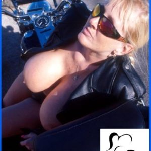 Elder model Kayla Kleevage puts her big breasts on display in leather by a motorcycle