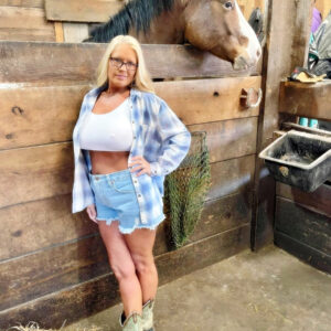Light-haired first-timer Maddie Cross unsheathes her hefty titties while getting naked in a horse stall