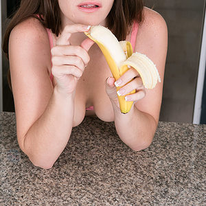 Young girl reveals her tiny breasts while peeling and eating a banana