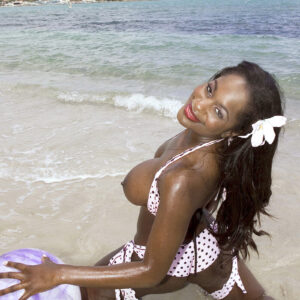 Ebony MILF Nikki Jaye pulls out her enhanced tits from her bikini top while at the beach