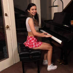 Skinny brunette Amber Angel plays the piano prior to masturbating